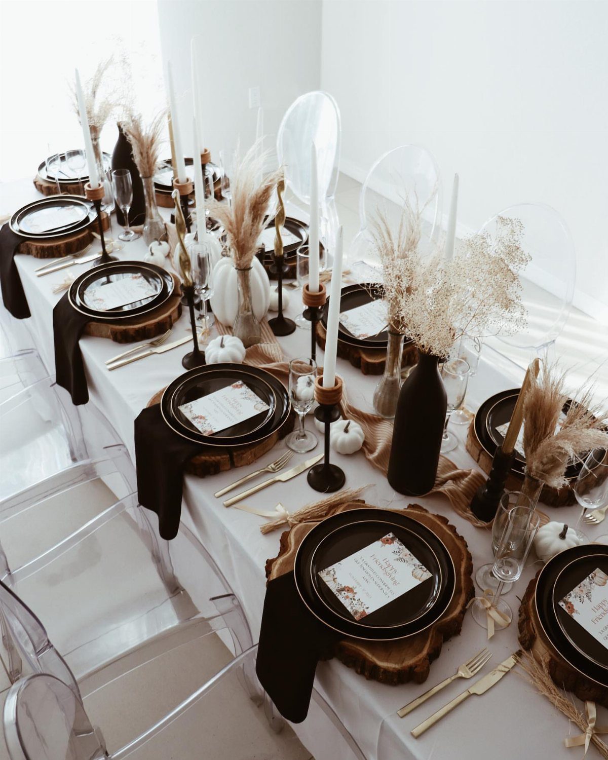 Black plates and white pumpkins on a modern white and black tablescape.