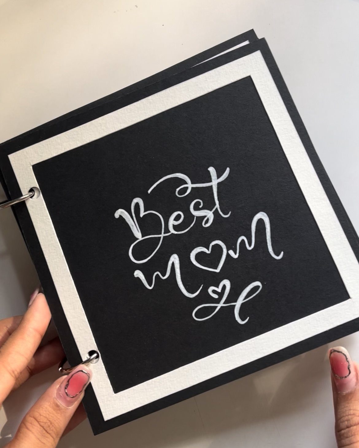 Handmade black picture book for Mom with white cursive lettering and heart symbol.