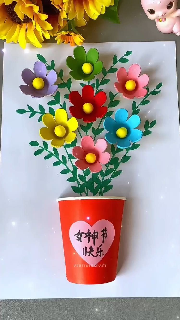 Egg carton flowers in a red paper cup with green paper leaves.
