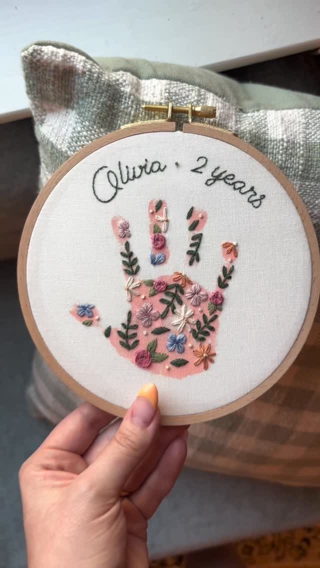 Embroidered handprint with colorful flowers in a wooden hoop with name and age.