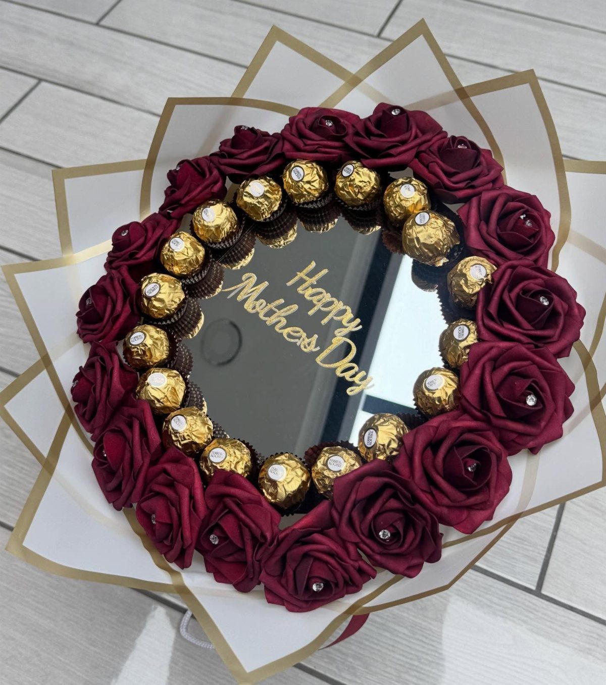 Mother's Day bouquet with red roses, gold chocolates, and a central mirror.