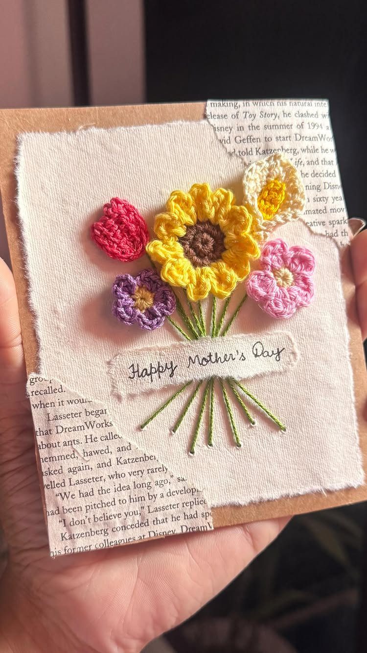 Handmade Mother's Day card with colorful yarn flowers embroidered on white fabric.