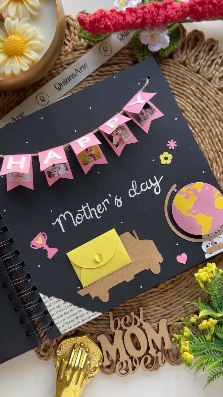 Decorated black spiral notebook for Mother's Day with photos, banner, and small envelope.