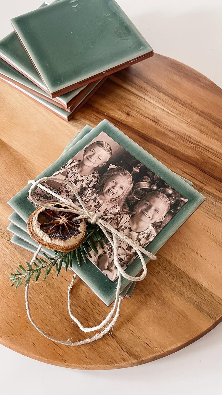 Square green ceramic coasters with a photo of children tied with twine.
