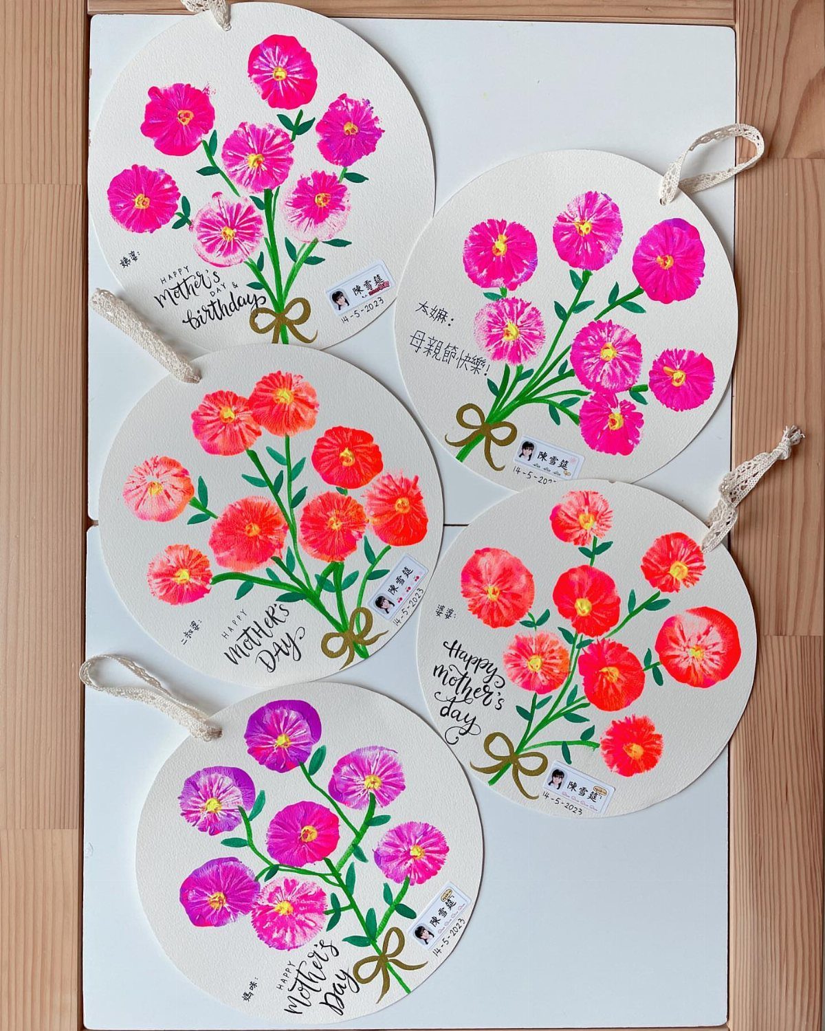 Circular paper ornaments with colorful painted flowers and Happy Mother's Day handwritten text.