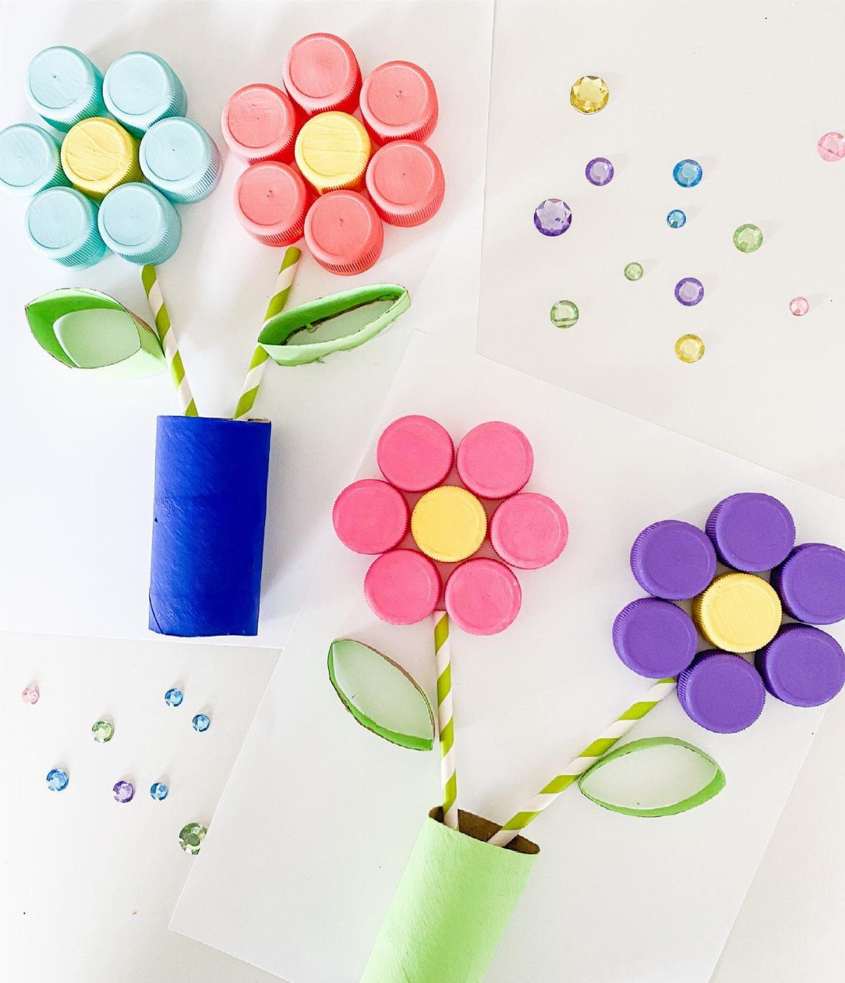 Bottle cap flowers with straw stems and cardboard tubes on white paper.