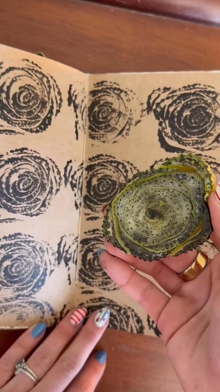 Celery stalk cross-section held over tan paper with black stamped floral patterns.