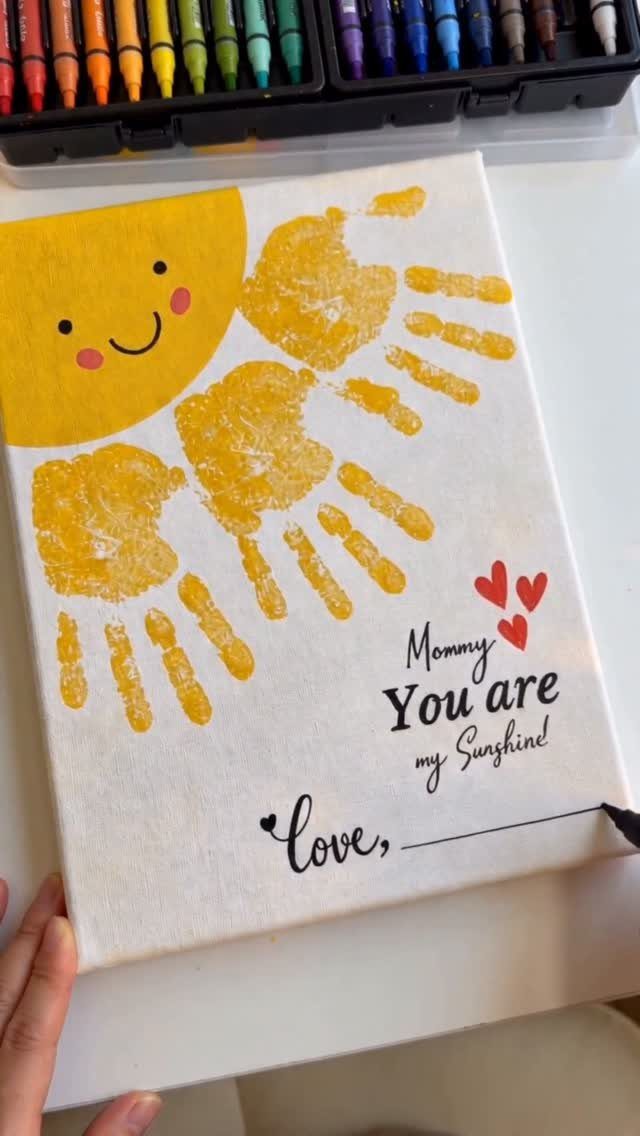 Yellow sun and handprint rays on a canvas with Mother's Day message