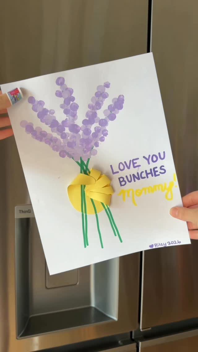 Finger-painted purple lavender bouquet with a yellow paper bow on white paper.