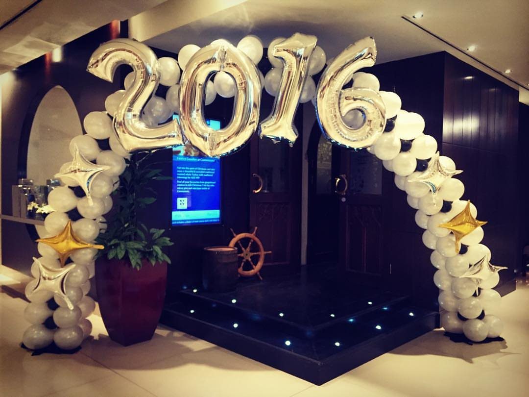 White balloon arch with silver 2016 foil balloons and gold star accents.