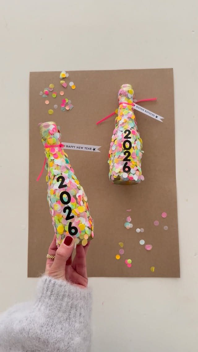 Small bottles covered in colorful confetti with 2026 numbers on brown paper background