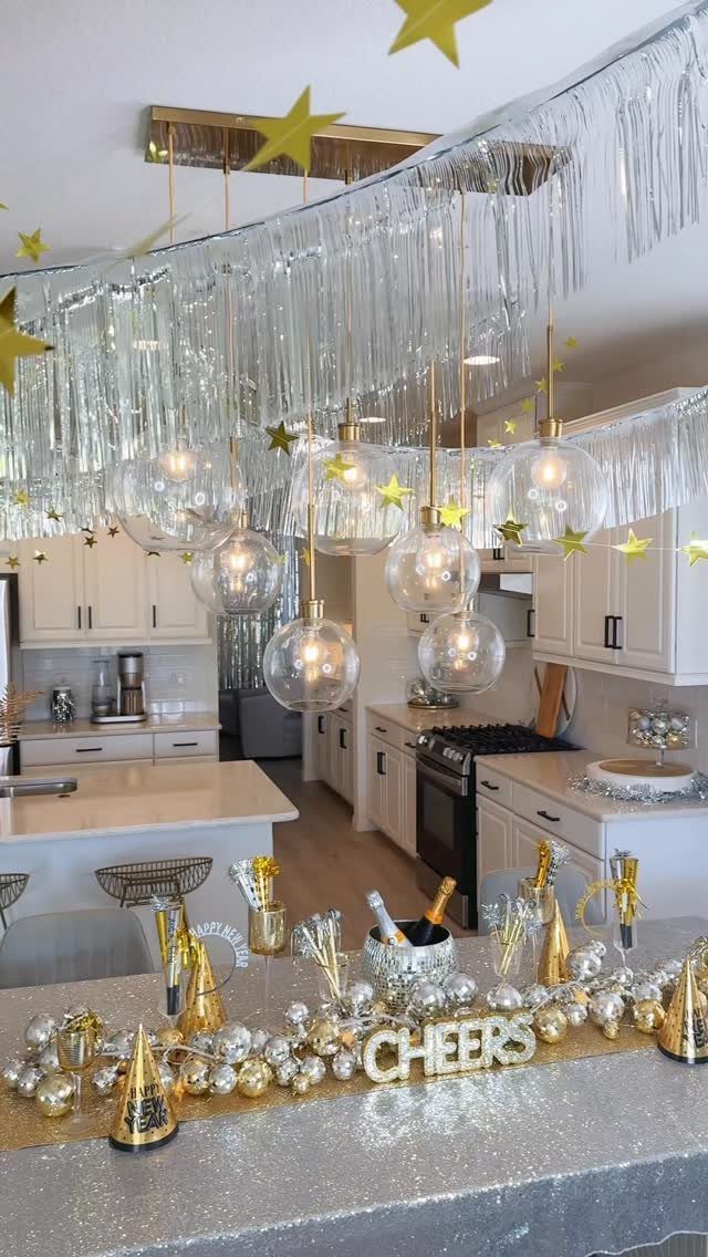 Festive party table with silver glitter cloth, gold hats, and champagne bottles.