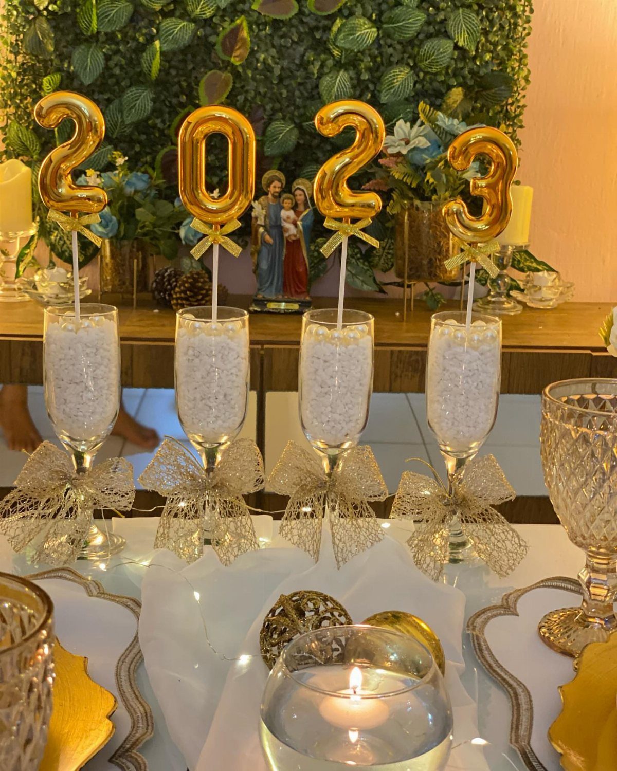 Champagne flutes with gold 2023 balloons and lace bows on a decorated table