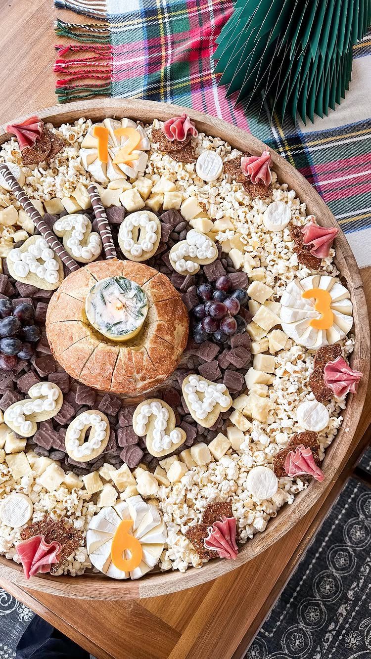 Charcuterie board arranged as a clock face with cheese numbers and 2024.