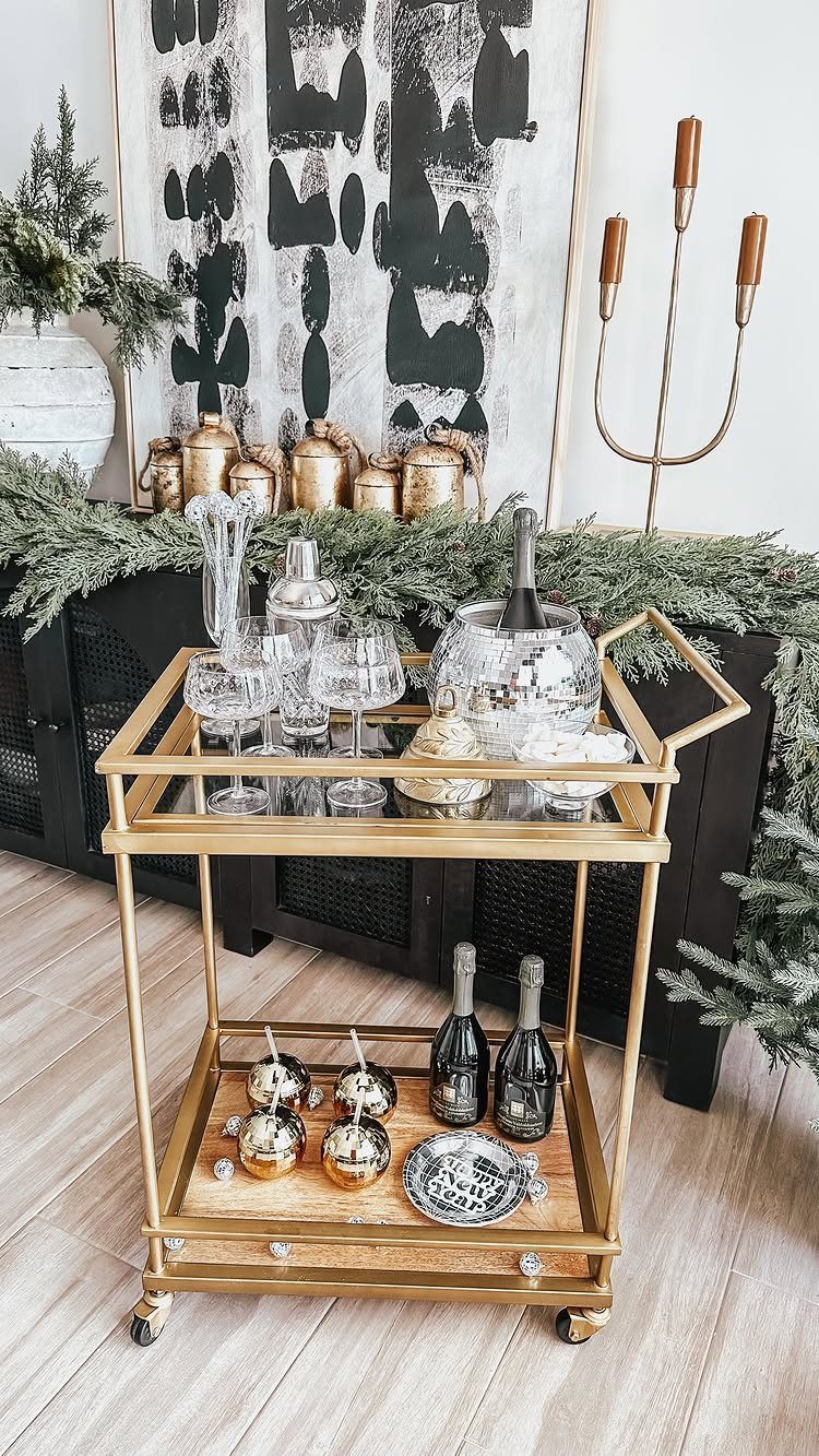 Gold bar cart with champagne glasses, bottles, and gold ornaments for a celebration.