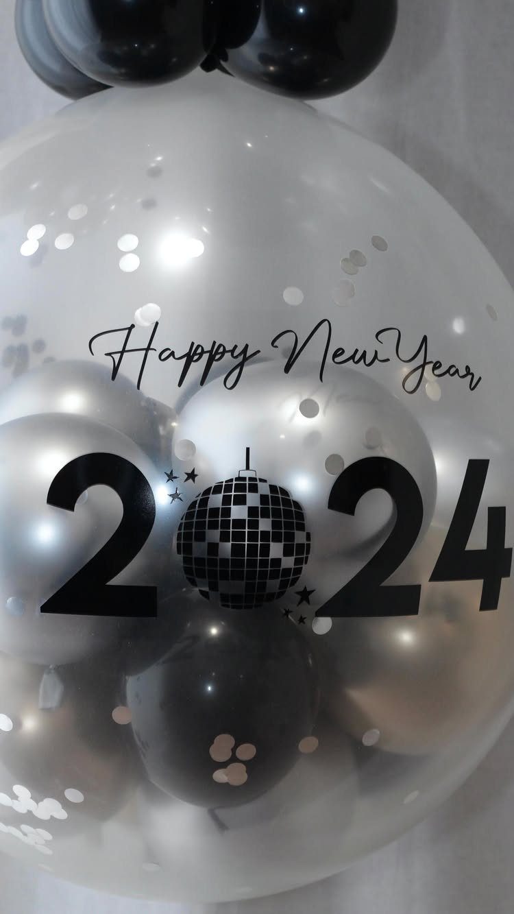 Clear balloon filled with smaller balloons and confetti featuring Happy New Year 2024 text