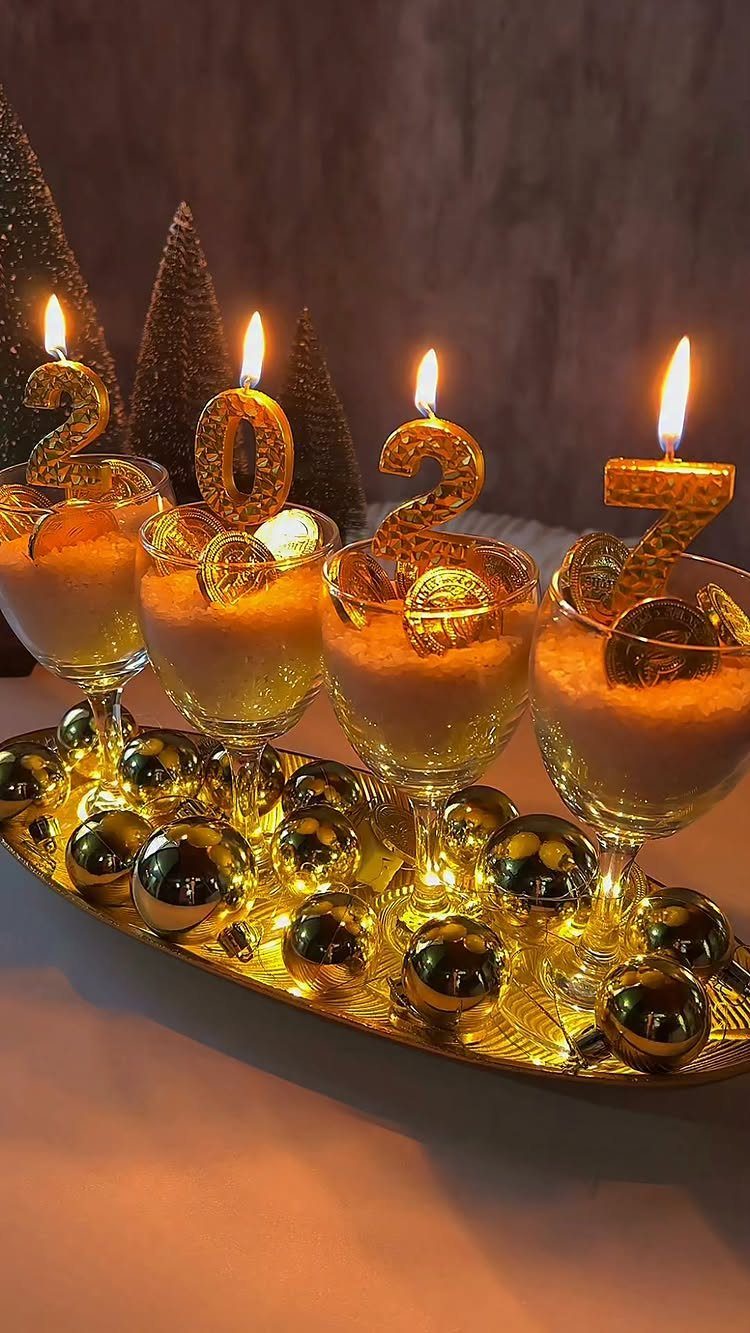 Champagne glasses with 2027 gold candles on a tray with festive ornaments.