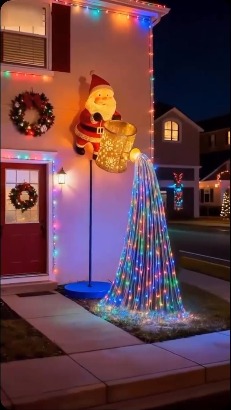 Santa figure pouring a cascade of colorful LED lights from a bucket onto a lawn