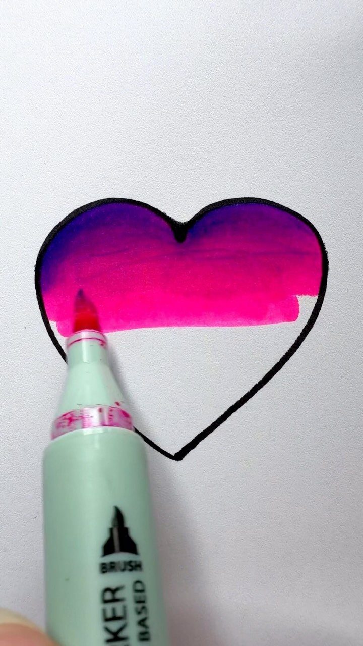 Brush marker coloring a heart outline with pink and purple ink on paper.