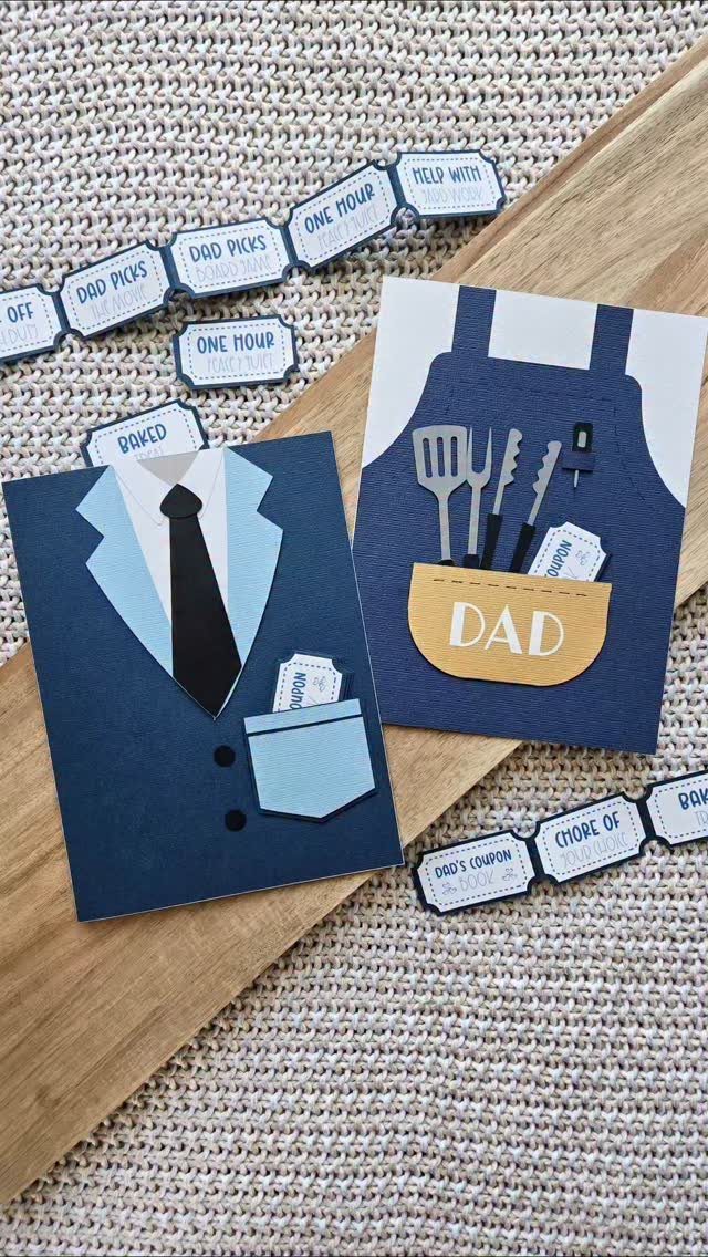 Handmade Father's Day cards and printed coupons on a wooden surface and fabric.