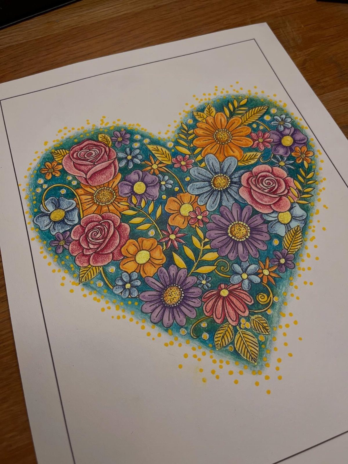 Heart shaped floral drawing colored with pink, purple, and yellow flowers on paper.