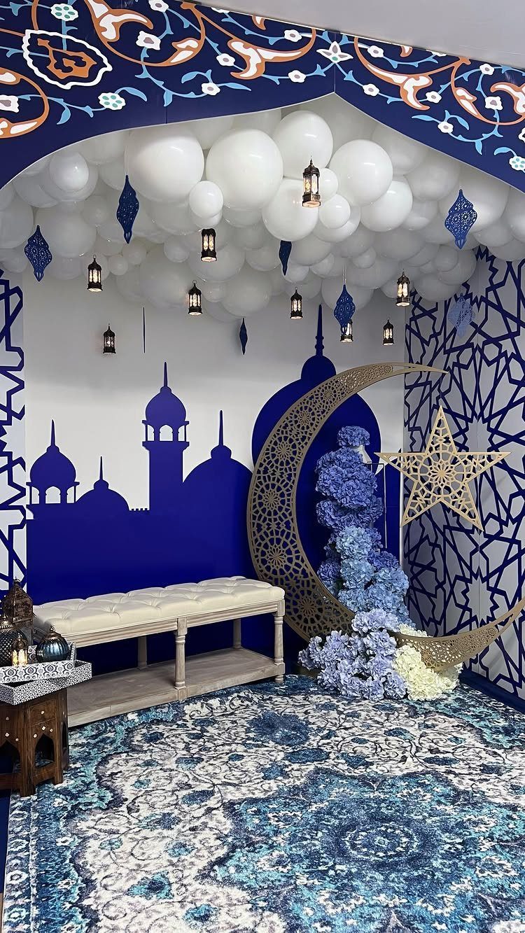 Decorated room with white ceiling balloons, gold crescent moon, and blue mosque silhouette.