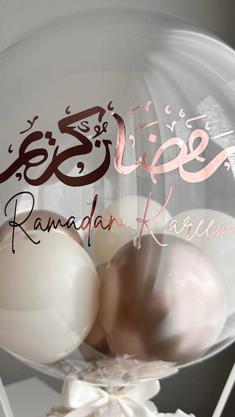 Clear balloon filled with smaller white and brown balloons featuring Ramadan Kareem text.
