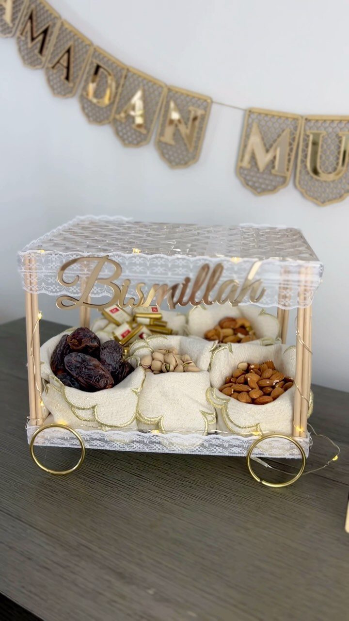 Decorative white cart with dates and nuts on a table with Ramadan banner.