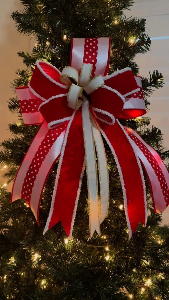 Red and white polka-dot ribbon bow on a lit green Christmas tree