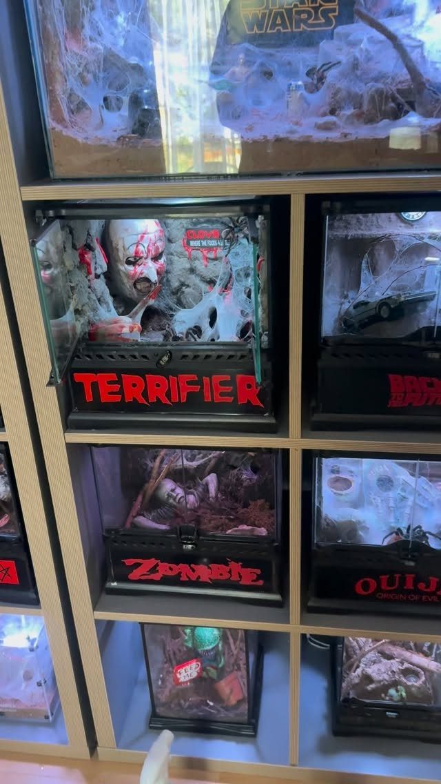 Horror-themed miniature dioramas with zombies and clowns displayed on a wooden shelf.