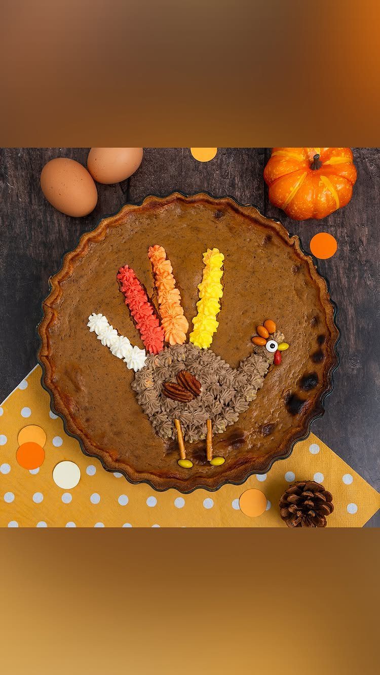 Pumpkin pie decorated with a turkey made from nuts and candy corn.