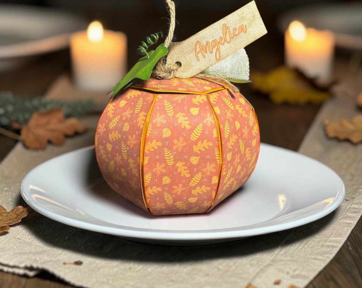 Paper pumpkin place card holder with name tag on a white dinner plate