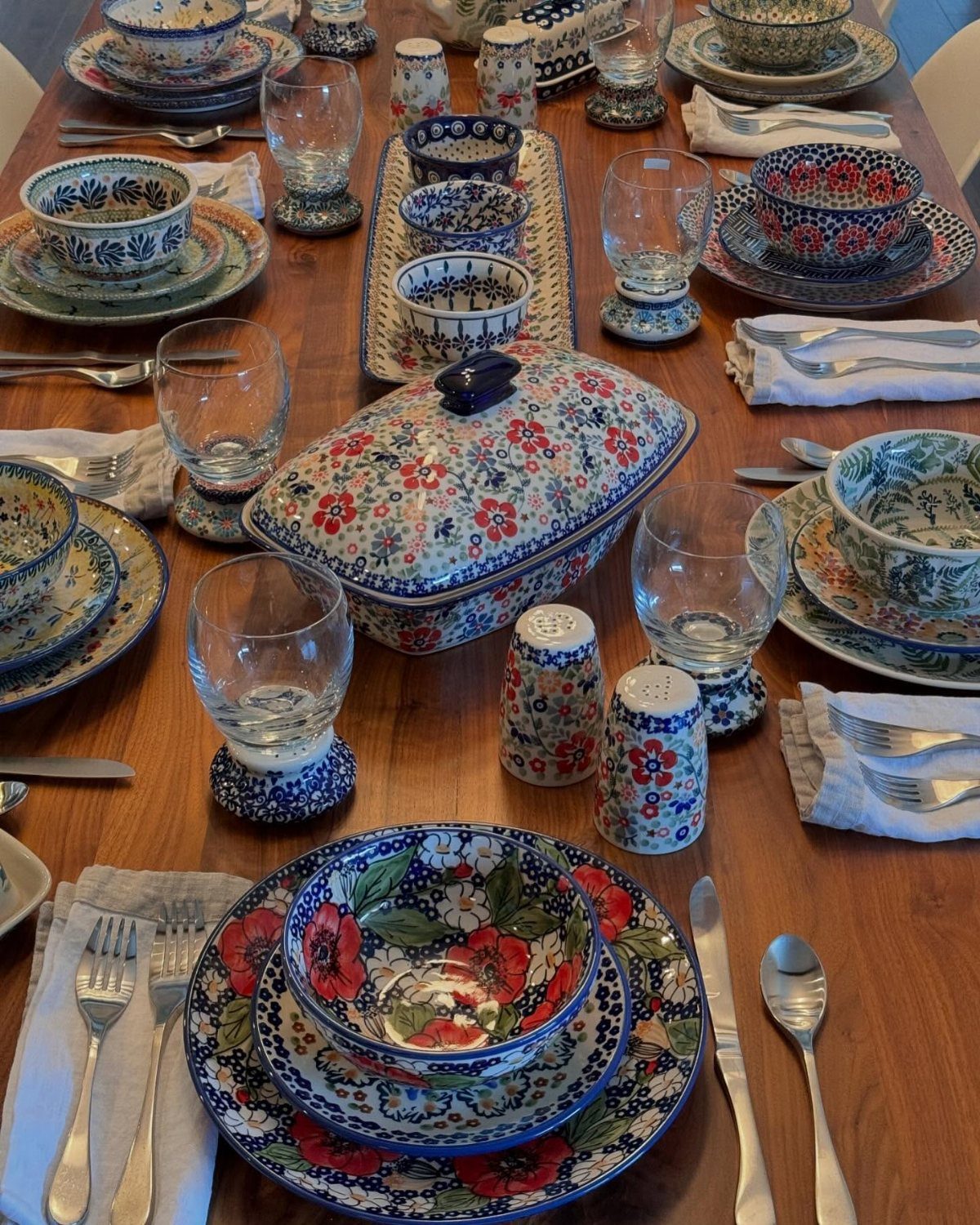 Patterned ceramic plates and bowls in blue and red on a wooden table.