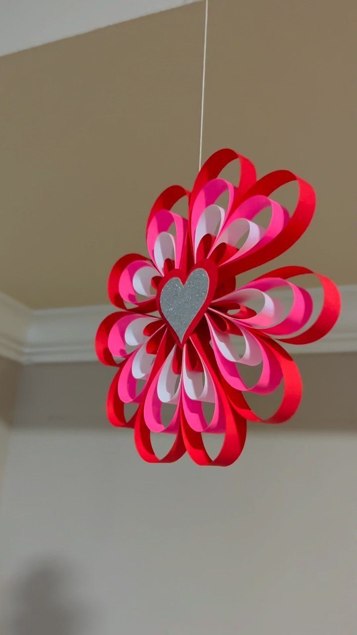 3D paper heart decoration with red, pink, and white loops and silver center