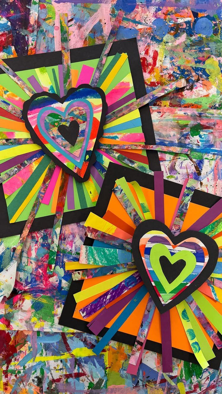 Colorful paper heart crafts with radiating strips on a paint-splattered background.