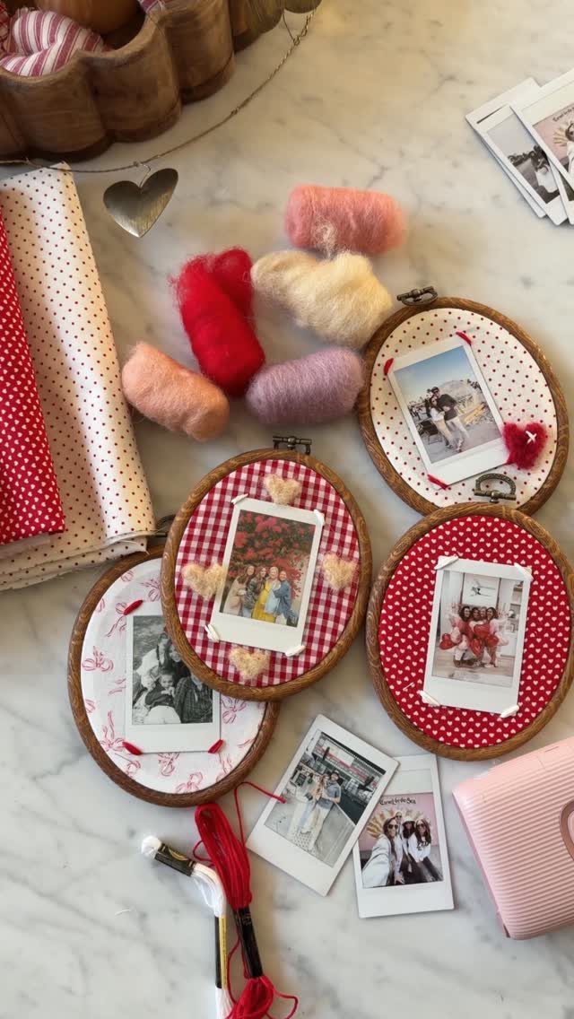 Wooden embroidery hoops with red patterned fabric and polaroid photos on marble surface.