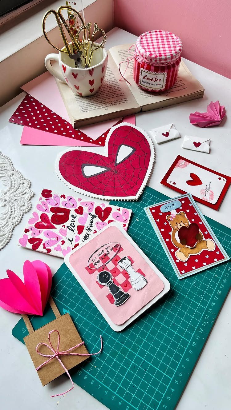 Handmade Valentine's Day cards with hearts and illustrations on a green cutting mat.