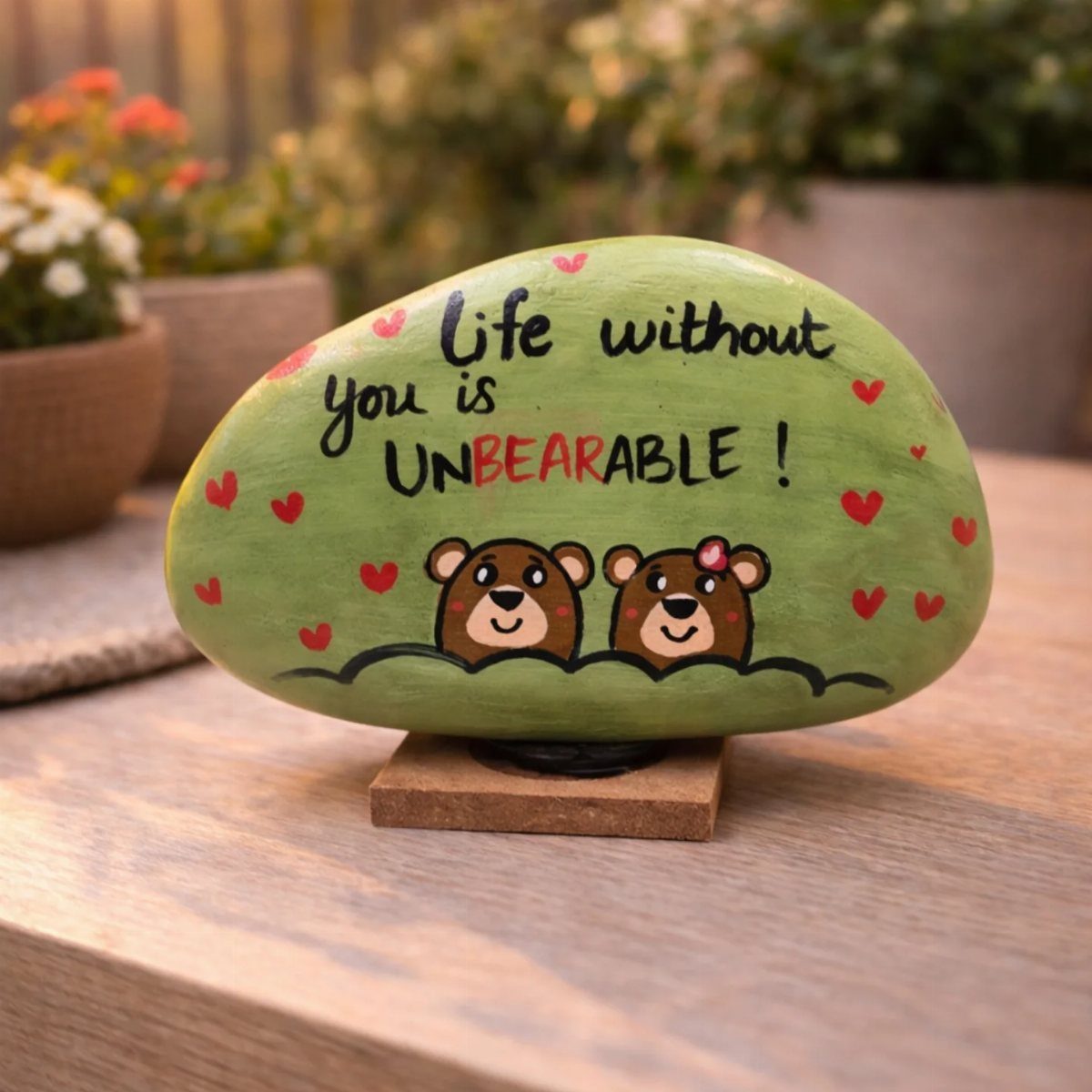 Painted green rock with two bears and a romantic pun for Valentine's Day.