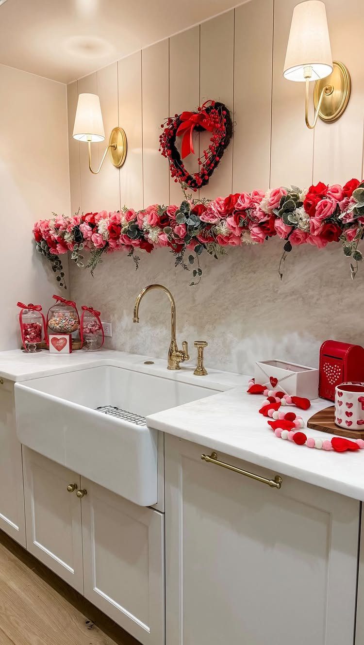 White bathroom vanity decorated with red heart wreath, rose garland, and candy jars.