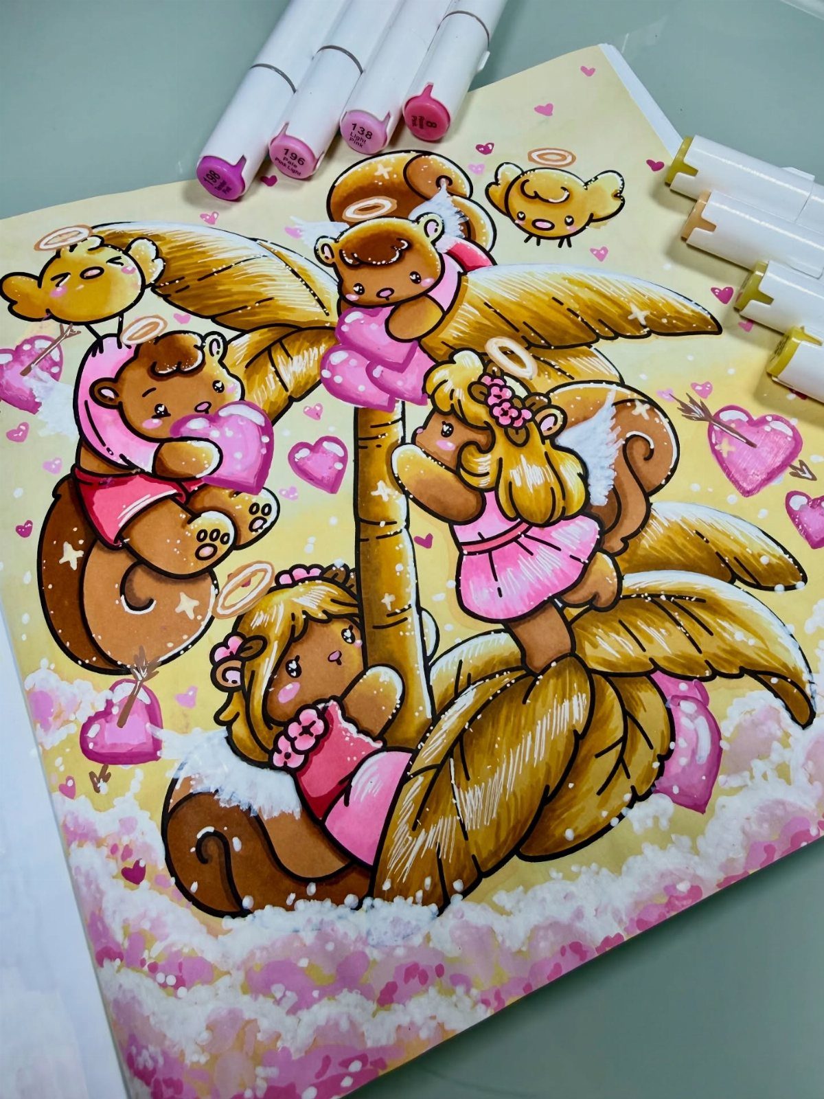 Colored drawing of winged squirrels and hearts with markers on a table