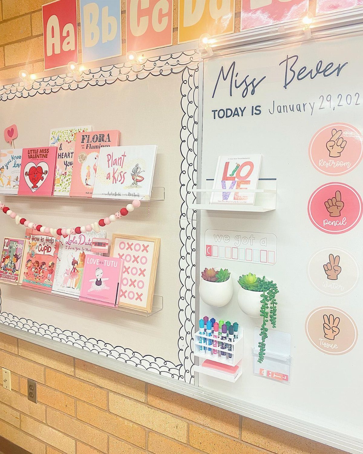 Valentine themed children's books displayed on shelves in a bright classroom setting.